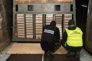 Funkcjonariusze SG i KAS zabezpieczają nielegalne papierosy ukryte w ściance działowej wagonu kolejowego