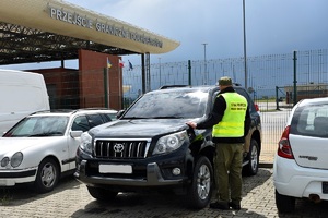 Funkcjonariusz SG prowadzi kontrolę legalności pochodzenia pojazdu na terenie drogowego przejścia granicznego w Dolhobyczowie