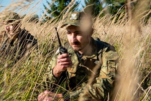 Funkcjonariusz SG podczas pełnionej służby prowadzi rozmowę przez radiotelefon