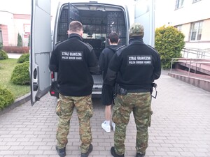 Funkcjonariusze podczas doprowadzenia do granicy państwowej osoby zatrzymanej