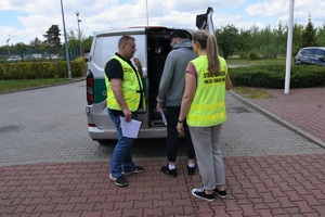 Funkcjonariusze SG doprowadzają do pojazdu służbowego zatrzymanego mężczyznę