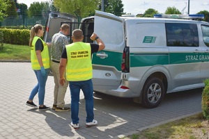Funkcjonariusze SG podczas doprowadzenia do pojazdu osoby zatrzymanej