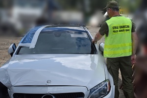 Funkcjonariusze SG zabezpieczają poszukiwany samochód marki Mercedes