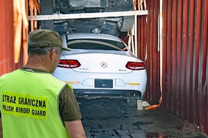 Funkcjonariusze SG zabezpieczają poszukiwany samochód marki Mercedes
